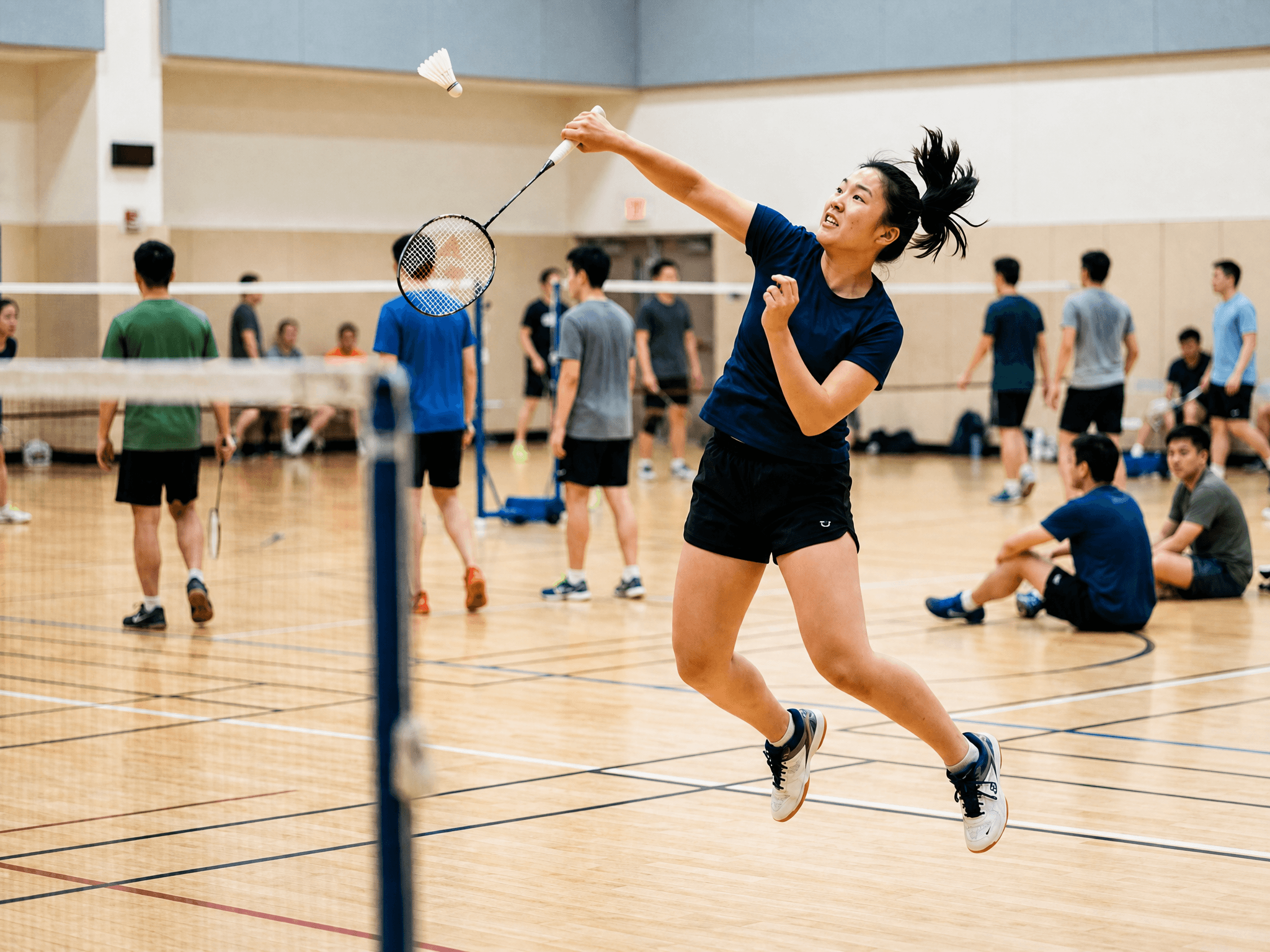 Badminton player leaping for a smash in an indoor Hong Kong court